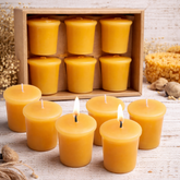 Beeswax candles with a wooden box of candles on a rustic wooden surface.