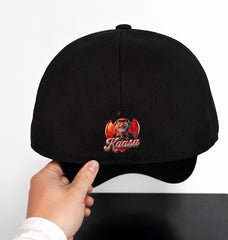 Black cap with embroidered design held by a hand on a white background