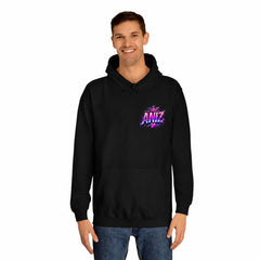 A man wearing a black pullover hoodie with a colorful 'I AM ANZ' graphic on the left chest, paired with blue jeans, against a plain white background.