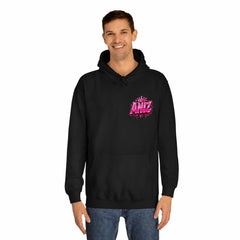 A man wearing a black pullover hoodie with a pink 'ANIZ' graphic on the left chest, paired with blue jeans, against a plain white background.