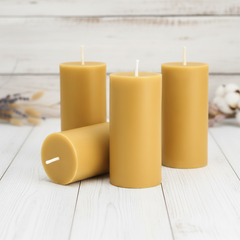 Four yellow candles on a white wooden surface with a light background