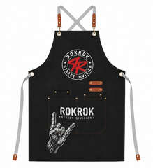A black apron with gray straps and brown leather accents, featuring 'ROKROK STREET DIVISION' graphics on the chest and front pocket.