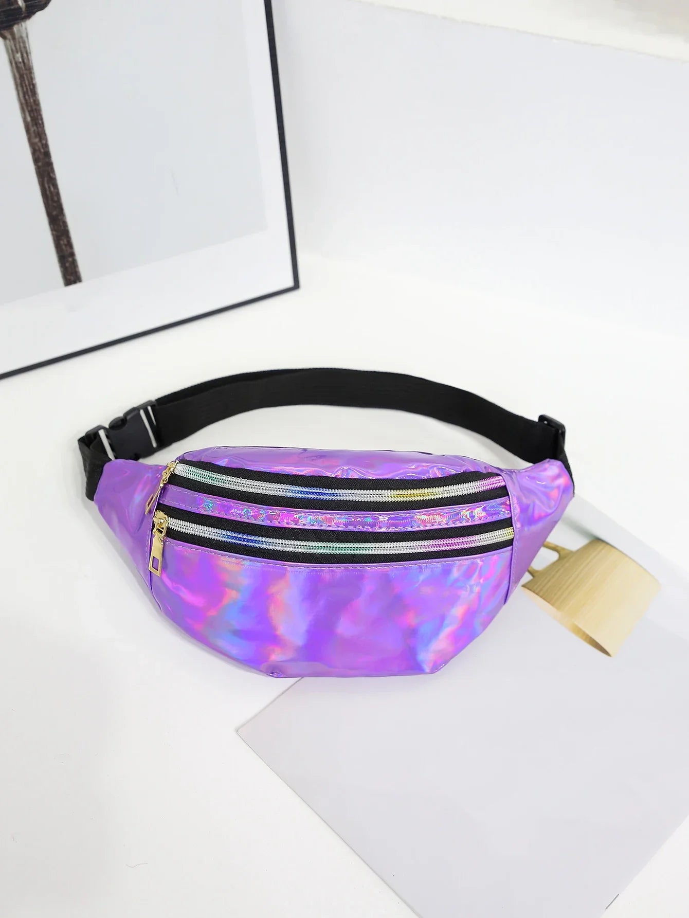 Purple reflective fanny pack on a white surface with a blurred background