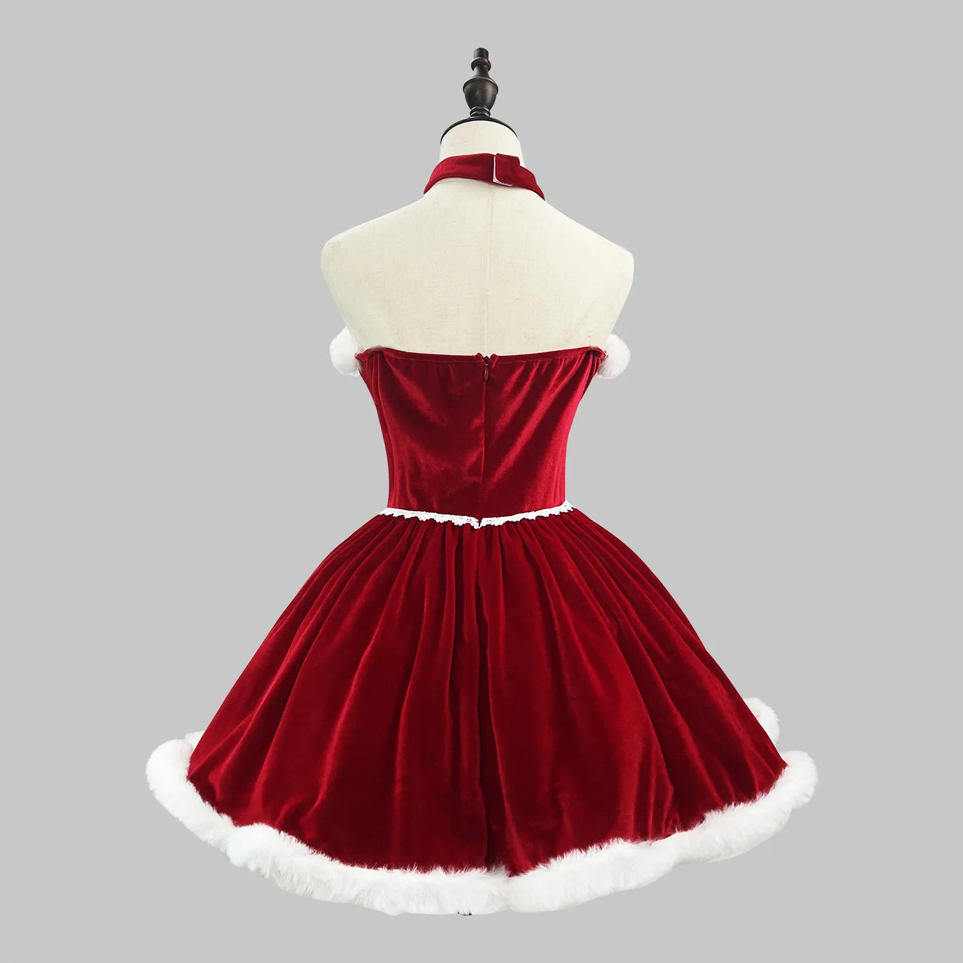 Red velvet dress with white trim on a mannequin against a gray background