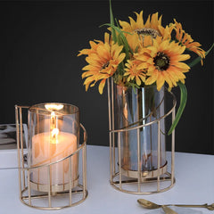 Decorative candle holder with a lit candle and a vase of sunflowers on a dark background