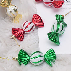Decorative candy ornaments in red, green, and gold on a soft white background.