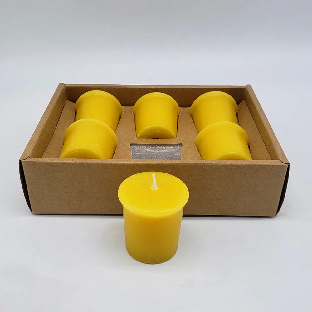 Set of yellow candles in a cardboard box on a white background