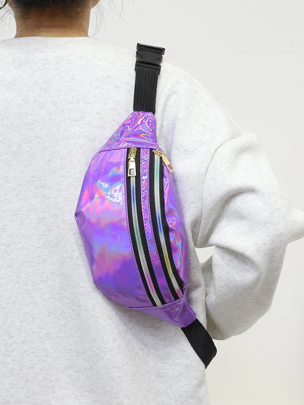 Person wearing a purple reflective bag with black straps on a white background