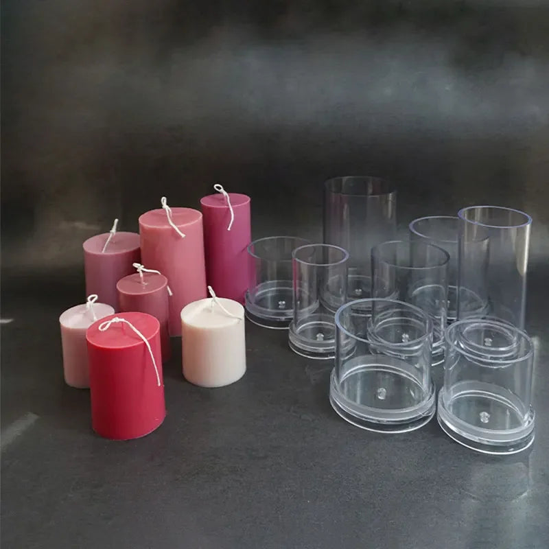Pink and red candles with clear glass candle holders on a dark surface