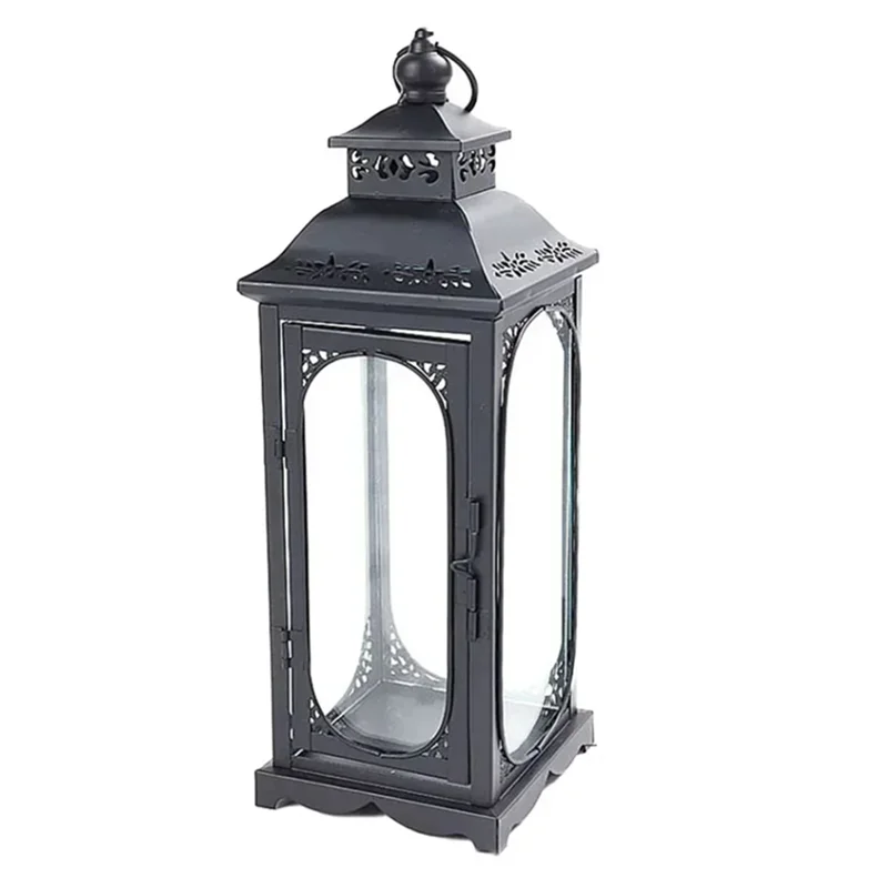 Black metal lantern with decorative design on a white background