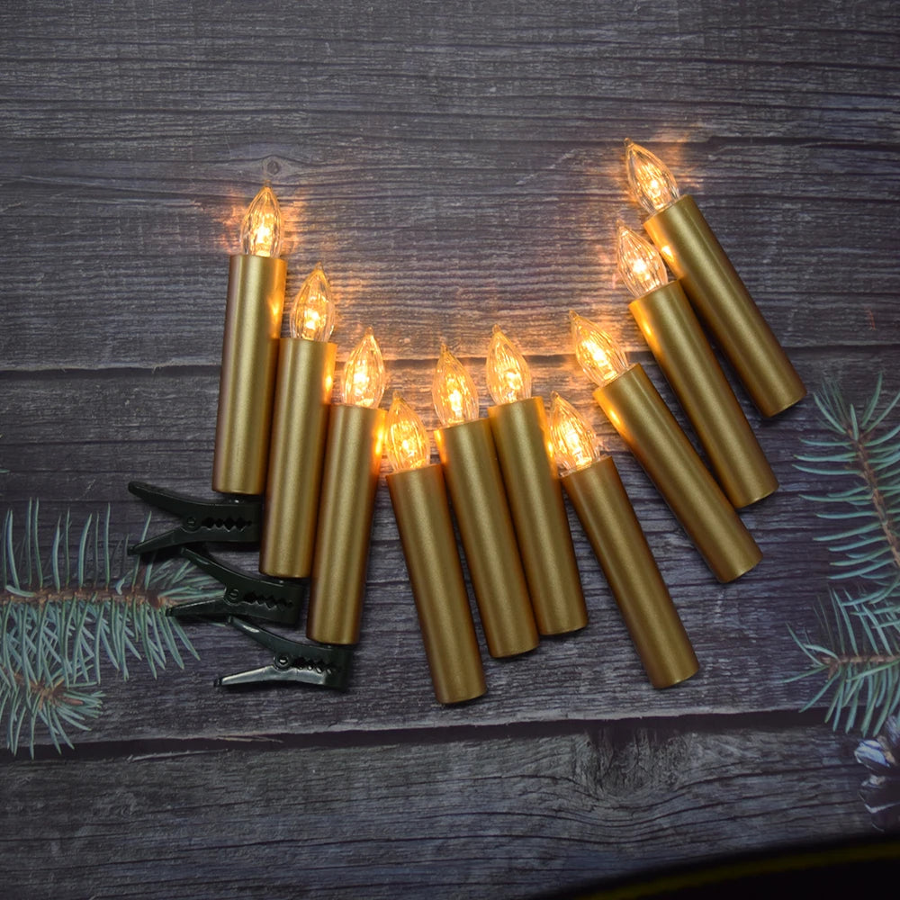 Set of gold candle-shaped string lights on a wooden surface with greenery.