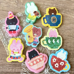 Set of colorful animal-themed stickers on a wooden surface