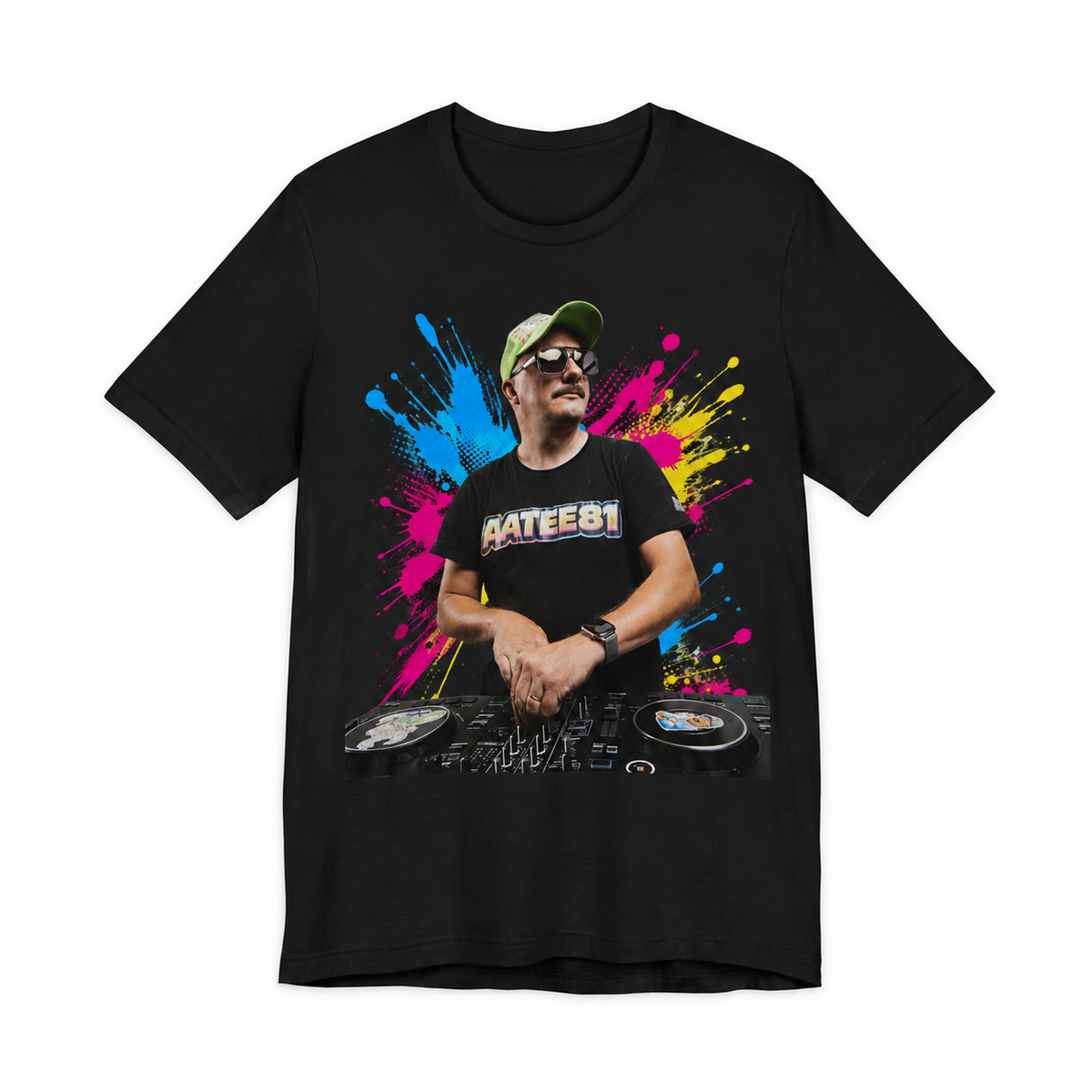 A black short-sleeve crewneck t-shirt featuring a colorful graphic print of a DJ in sunglasses behind turntables, set against a vibrant pink, blue, and yellow paint splatter background. The text 'DJATEE81' is printed across the chest.