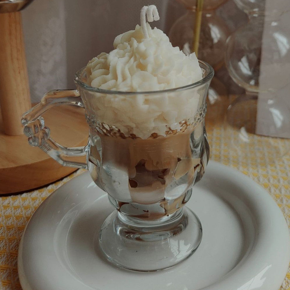 Glass mug filled with layered dessert on a white plate