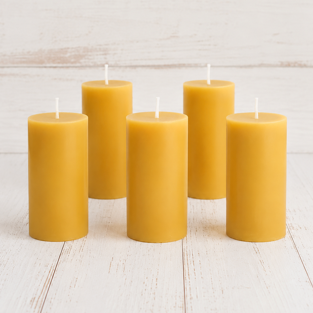 Five yellow candles on a light wooden surface